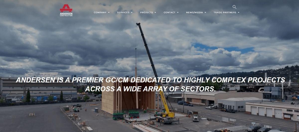 Construction-site photo with a crane lifting a wooden structure, cloudy sky, and the overlay slogan: 'Andersen is a premier GC/CM dedicated to highly complex projects across a wide array of sectors.' (logo top-left)