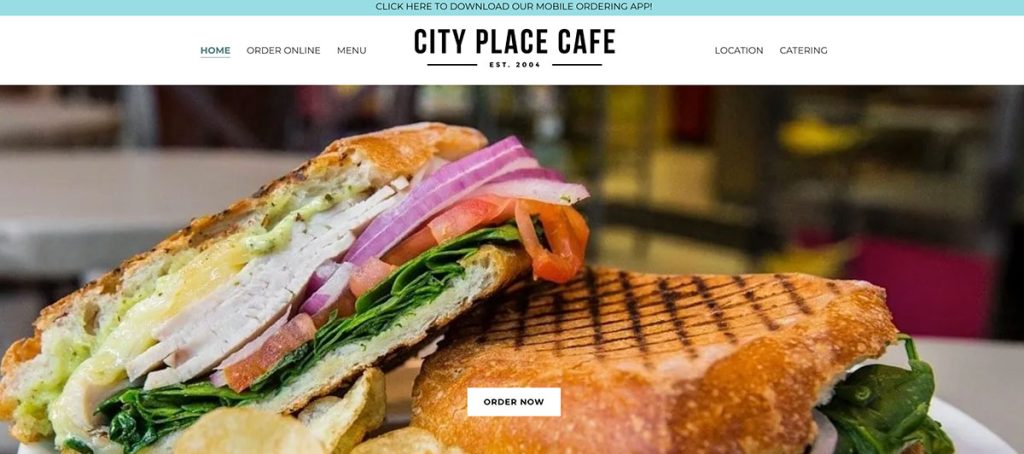 Hero image of a grilled panini sandwich filled with turkey, greens, tomatoes, onions and melted cheese on crusty bread at City Place Cafe. Visit to order now.