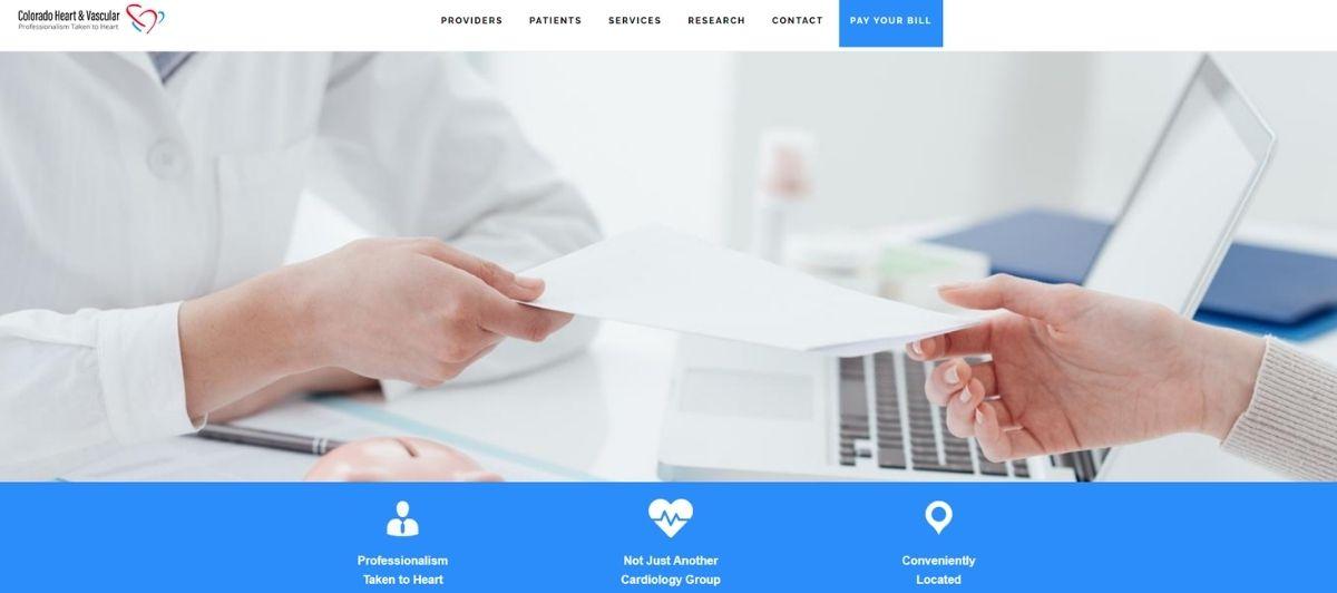 Medical professional hands a document to a patient across a clinic desk, with a laptop nearby, in a healthcare setting