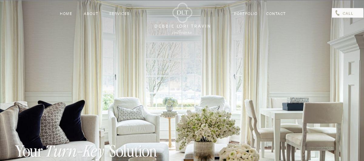 Bright white living room with plush seating and large windows, serving as the hero image for Debbie Lori Travin Interiors.