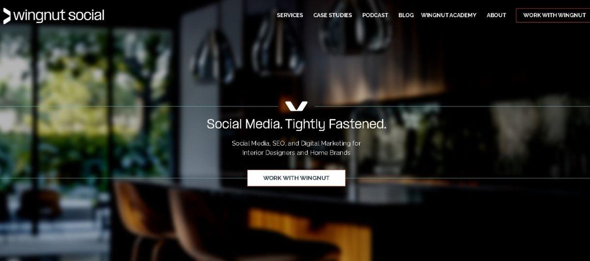 Hero header for Wingnut Social with a blurred office background, centered slogan “Social Media. Tightly Fastened.” and a “Work with Wingnut” button.