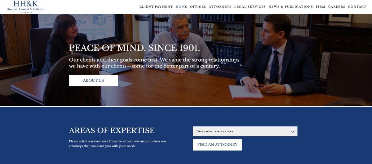 Law firm homepage hero: three attorneys seated around a wooden conference table in a library-style office, with the tagline 'Peace of Mind. Since 1901.'
