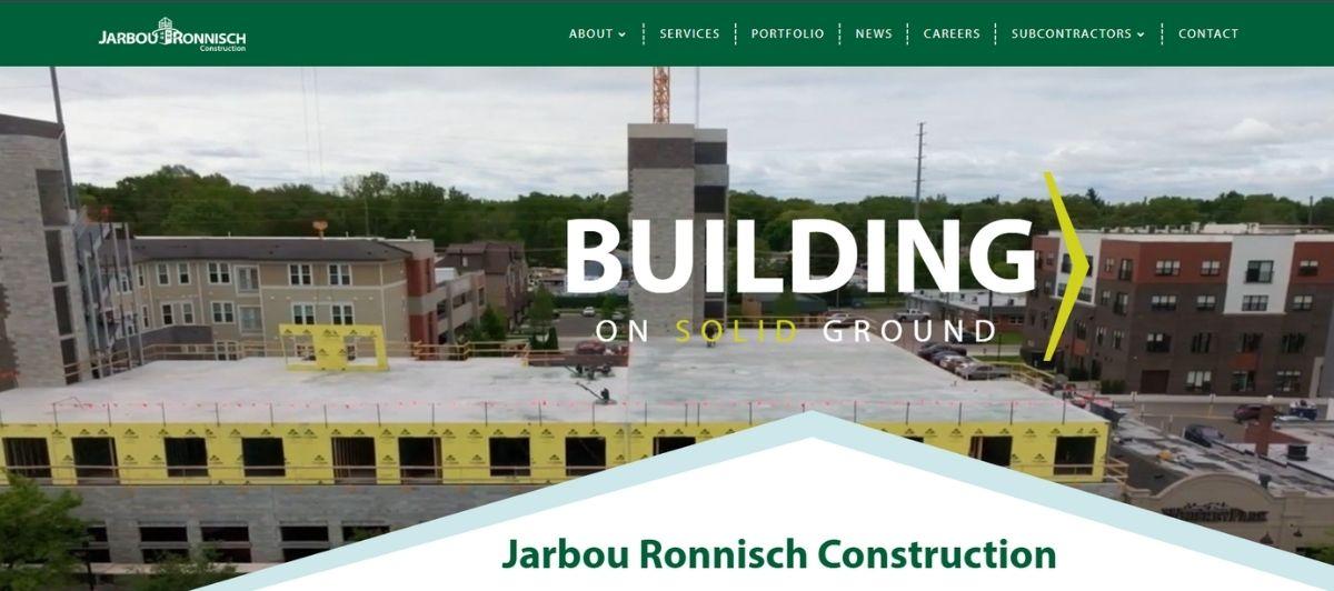 Aerial view of a construction site with a partially built building and a large white 'BUILDING ON SOLID GROUND' overlay, showcasing the company branding at the top.