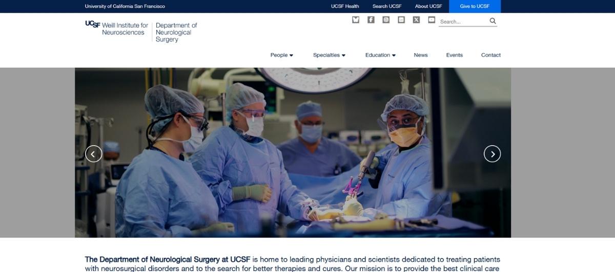 Surgical team in blue scrubs and masks performing an operation in an operating room with a bright overhead light.