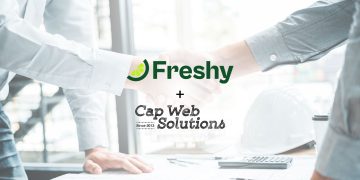 Handshake between business professionals with Freshy and Cap Web Solutions logos overlaid in the foreground, suggesting a partnership.