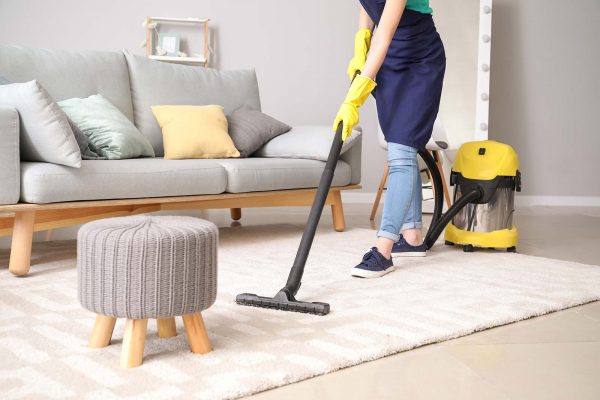 Woman cleaning house with vacuum