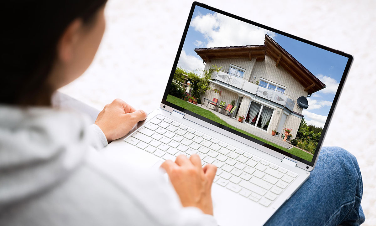 person on laptop looking at real estate