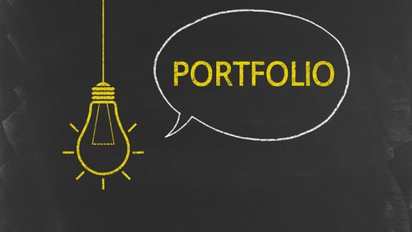 Yellow chalk-drawn lightbulb on the left and a white speech bubble containing the word PORTFOLIO on a dark chalkboard background