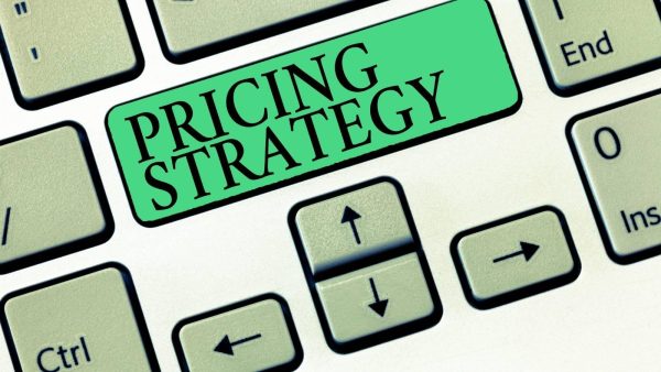 Green keyboard key reading 'PRICING STRATEGY' among standard keys, symbolizing pricing strategy involvement in decision making.