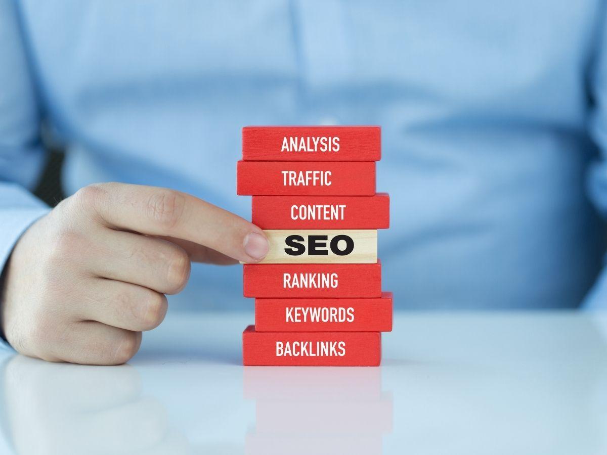 Stack of red blocks labeled Analysis, Traffic, Content, SEO, Ranking, Keywords, Backlinks, representing SEO components.